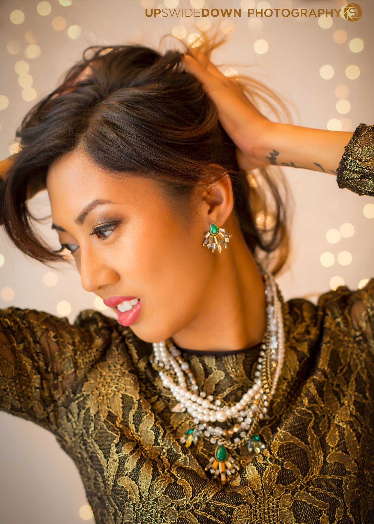 Fashion portrait featuring layered jewelry and warm light