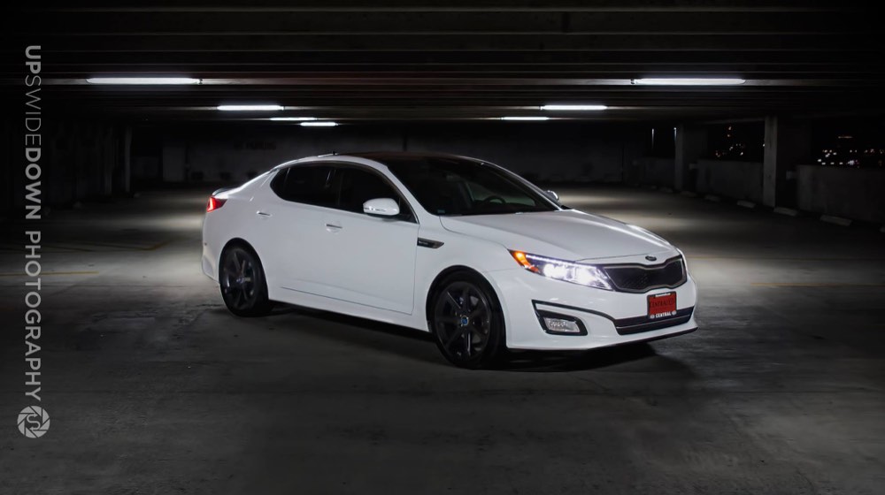 White Kia Optima photographed under garage lighting