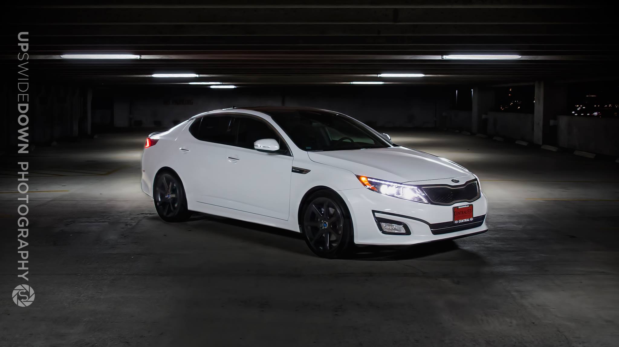 White Kia Optima photographed under garage lighting